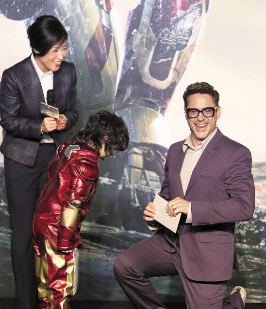 唐尼单膝跪地，双手抱拳接过请柬